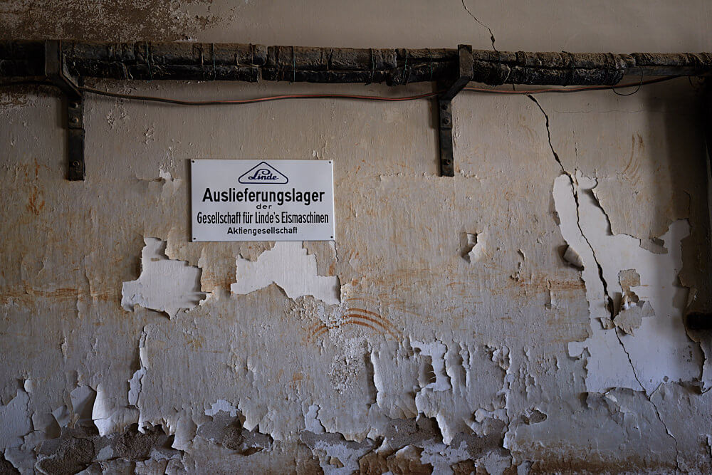 Das Bild zeigt ein Schild 'Auslieferungslager' der Firma Linde  in Kolmannskuppe in der alten Eisfabrik