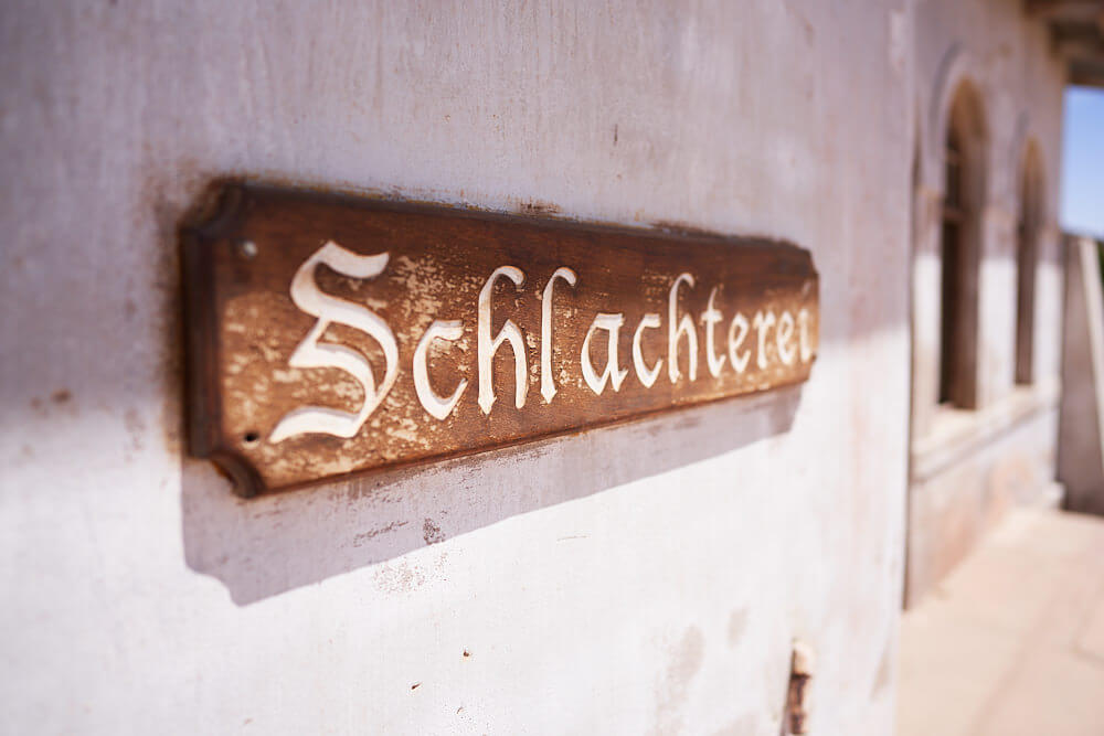 The picture shows the lettering 'slaughterhouse' in Kolmanskop