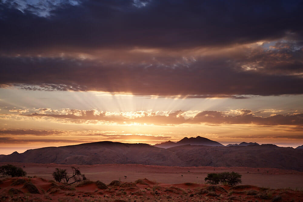 Dieses Bild zeigt einen Sonnenaufgang in der Namib im NamibRand Nature Reserve