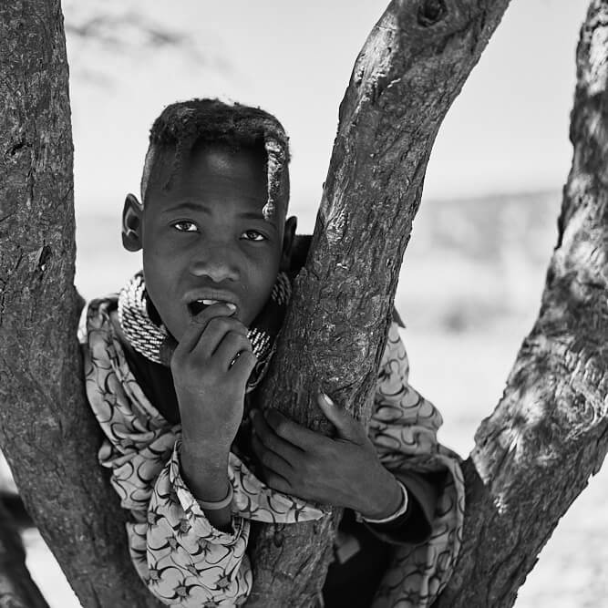 The picture shows the portrait of a young Himba