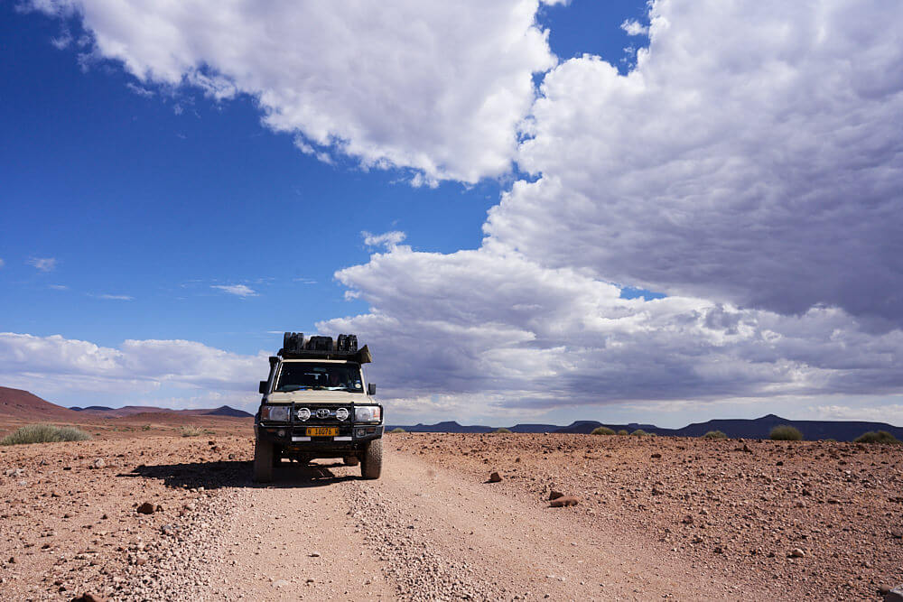 Das Bild zeigt unseren Land Cruiser 76 auf einer Schotterpiste in Palmwag