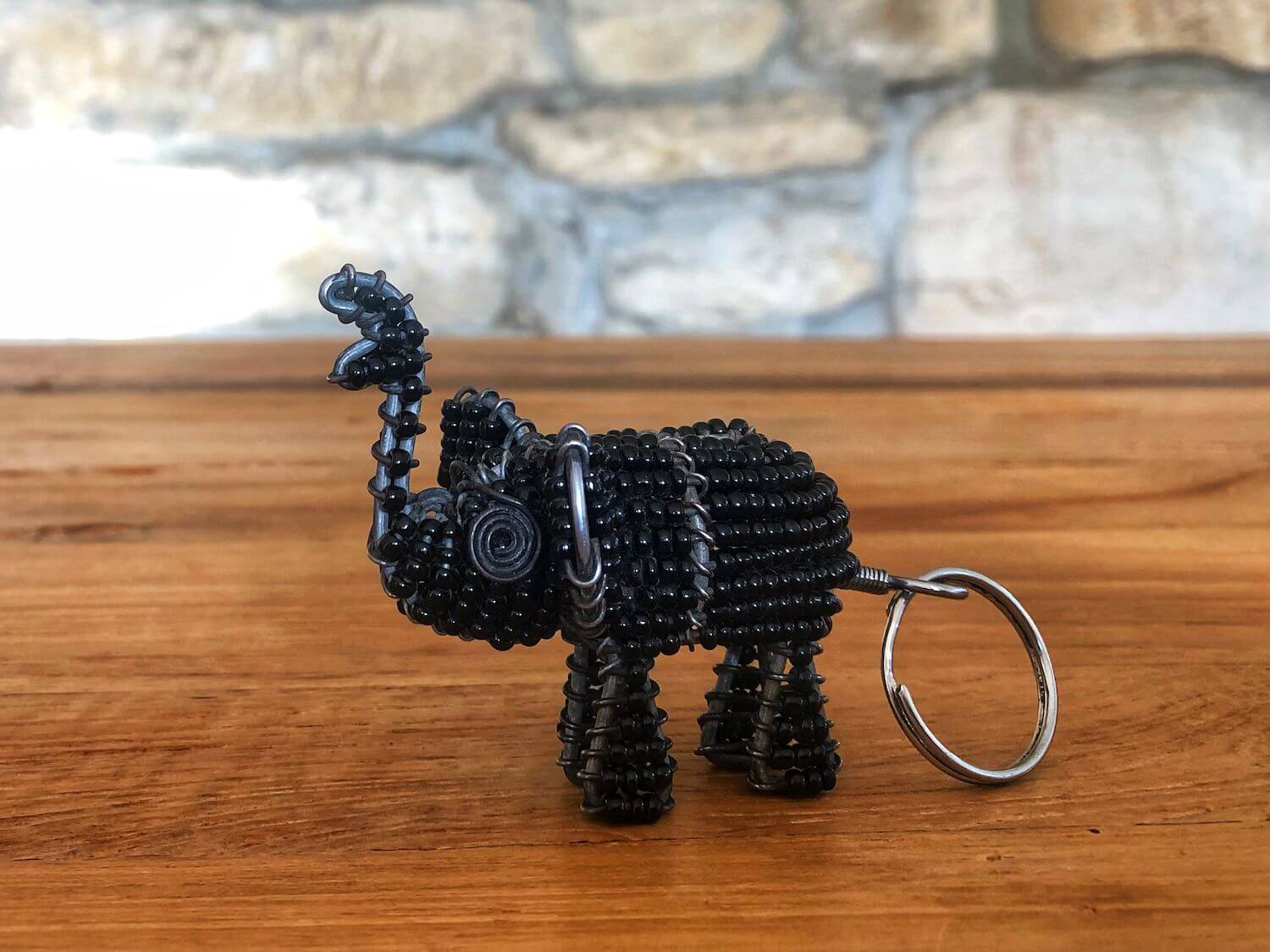 Das Bild zeigt einen Schlüsselanhänger, der aus Metall gefertigt ist und einen Elefanten darstellt. Gefertigt wurde er von einem Künstler aus Windhoek.